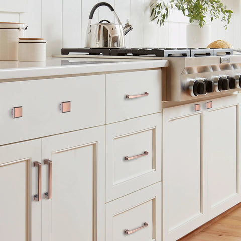 5 Inch Brushed Antique Copper Cabinet Hardware Pulls And Knobs Set installed on white kitchen cabinets.
