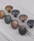 Antique Brass Cabinet Knobs Set Of 4 1.4 Inch Round Vintage Dresser Drawer Handles For Cabinets And Furniture Rustic Flower Shaped Design Durable Zinc Alloy Finish displayed in various finishes on a light background.