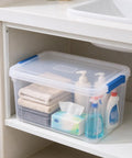 Heavy Duty 15 Quart Latching Storage Bin With Secure Lock Tight Lid And Crystal Clear Window holding towels and cleaning supplies.