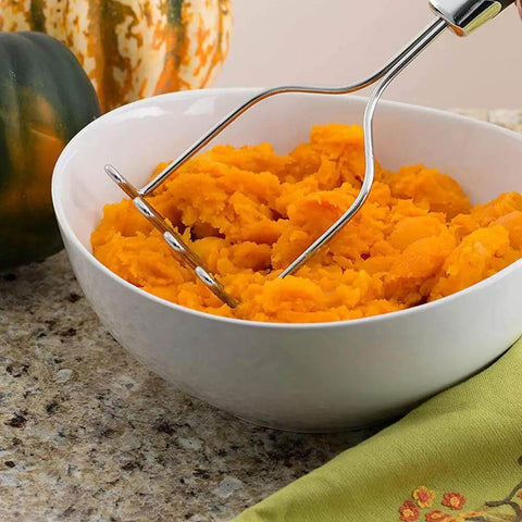 Ultimate 33-Piece Silicone And Stainless Steel Utensil Set potato masher in use over a bowl of mashed potatoes