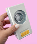 Hand holding 1.25 Inch Circle Punch With Safety Lock for card making, scrapbooking, gift tags, on a pink background