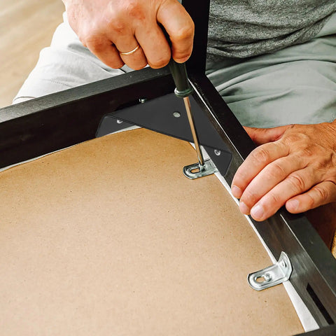 Person installing 12 Pack Heavy Duty Universal Corner Braces For Furniture And Tables Black Steel Triangle Right Angle Shelf Brackets