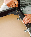 Installing Beefy Black Metal Corner Brackets Set Heavy Duty Right Angle Shelf Braces for Cabinets and Tables with screwdriver