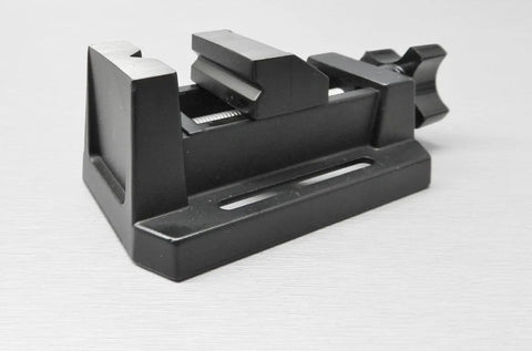 Compact Table Vise For Bench And Drill Press, Mini Precision Vise For Jewelry Hobbyists, Zinc Die Cast Construction, Grips Small Parts With Horizontal And Vertical V Grooves, Mounting Slots With Bolts Washers And Wing Nuts Included. black mini vise side view with base slot