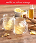 Four Piece Double Wall Insulated Glass Coffee Mug Set Keeps Hot Brews Steaming And Icy Drinks Frosty With Zero Sweat Marks Premium Borosilicate Glass Is Dishwasher Safe For Your Daily Grind Routine showing two mugs with herbal tea and lemon.