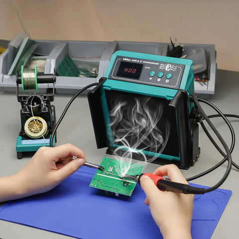 2-In-1 Soldering Station With Built-In Fume Extractor And 110W Iron in use, showing PCB work with smoke absorption on desk