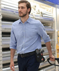 Person wearing Universal Barcode Scanner Holster With Open Face Access, Belt Loop And Clip Attachment in a warehouse setting.