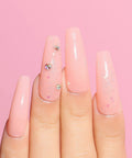 Hand with glossy, pink nails enhanced by the HEMA Free Rubber Base Gel Kit For Nails Soak Off UV LED Clear Sheer Gel Polish.