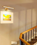 Wall-mounted sleek 24 Inch Picture Light in matte black illuminating art in hallway, plug in or hardwired, for modern decor.