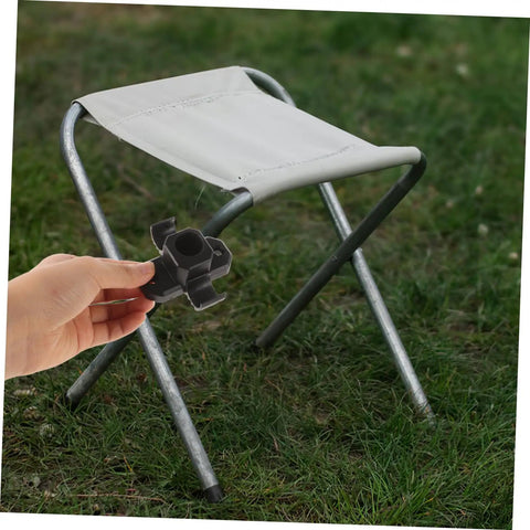 Heavy Duty 4 Pack Furniture Leg Mount Brackets Corner Connector Hardware For Table Chair Camping Stool Repair Pre Drilled Plates held next to a folding stool.