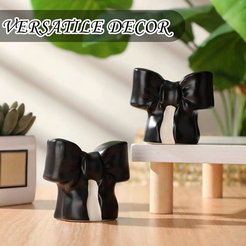 Black Coquette Bow Toilet Bolt Covers Set Of Two - Durable Ceramic Screw Nut Caps For Bathrooms displayed on a table.