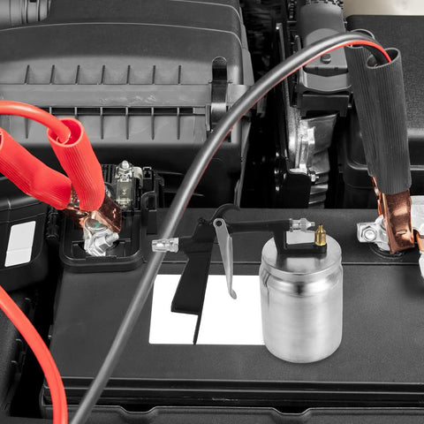 Close-up of Real Deal Pneumatic Paint Sprayer with tough metal housing on a car battery for high precision atomization.