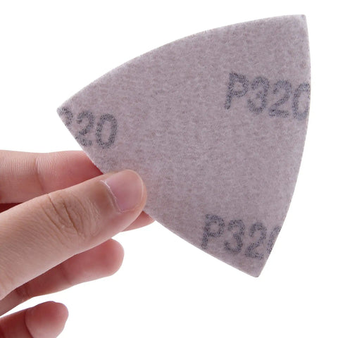 Hand holding a P320 Triangle Sanding Pads Set For 3-1/8 Inch Oscillating Multi Tools, 100 pcs, hook and loop, no holes, 80x80x80mm pad for finishes.