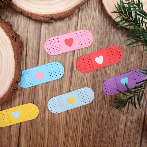 Colorful adhesive bandage-shaped die cuts with hearts on wooden surface, showcasing Happy Birthday Balloons Metal Cutting Dies For Card Making.