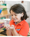 Child holding Cup Of Caterpillars Refill Kit With Five Live Painted Lady Caterpillars And Food Included, Chrys A Lid Log Included.
