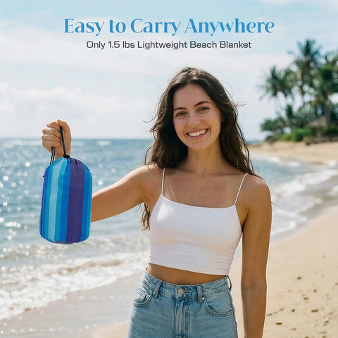 Woman holding Extra Large Beach Blanket Waterproof And Sand Free For 3 To 4 People 7 By 7 Feet Lightweight Beach Mat, packaged in a bag