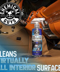 Chemical Guys Total Interior Cleaner & Protectant spray bottle, front view in car interior; clear bottle with blue label