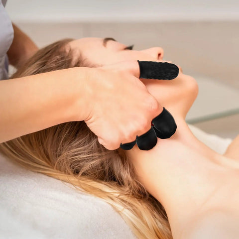 100 Pack Black Silicone Finger Cots And Protective Toppers For Manicures And Massage Sessions Soft Disposable Fingertip Shields in use during a massage.