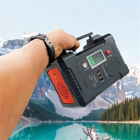 Portable AC Power Station With Fast Charging Ports, Campground Essential Backup Generator for road trips held by hand in scenic outdoor setting.