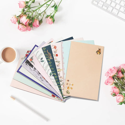 Ultimate 91 Piece Stationery Set with vintage-style lined papers, floral designs, and coffee on white desk