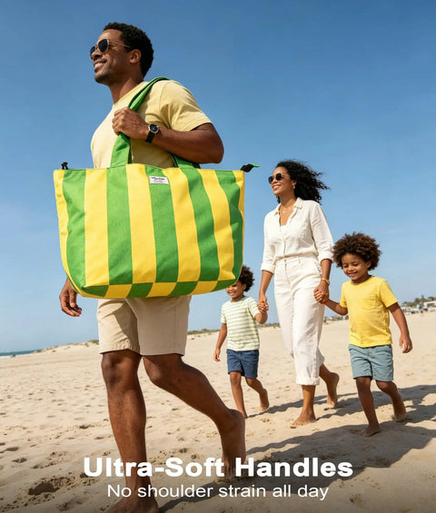 Man carrying large striped beach bag with family at the beach