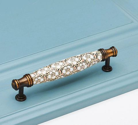 Two Pack Ceramic And Zinc Alloy Vintage Cabinet Knobs in rich brown with floral motif installed on blue cabinet, 5-inch hole spacing.