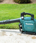 Game Changing Cordless Leaf Blower Kit Equipped With A Brushless Motor. Teal 36V blower on driveway for easy cleanup.