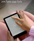 User holding Kindle Paperwhite Signature Edition 7 Inch E Reader with 32GB storage showing text on screen.