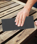 Person using Grab This 45 Sheet Wet Dry Sandpaper Set From 120 To 5000 Grit on wood surface for smoothing.