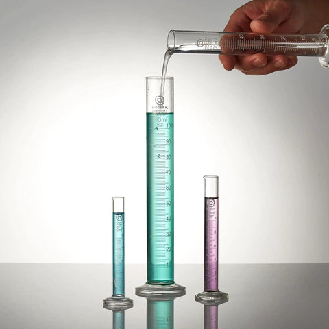 Top Shelf Borosilicate Glass Graduated Cylinders That Get The Job Done Fast In Any Lab Setup With Crisp Volume Readings For Chemistry Class And Science Fair Projects Five Ml Pack in use with colored liquids.