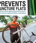 Cyclist holding a bike with a Bike Tire Liner That Prevents Flats And Punctures With A Tough TPU Shield For 24 To 29 Inch Mountain And Road Tires.