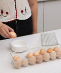 Person using Clear 14 Egg Organizer Tray For Refrigerator Narrow Stackable Dispenser No Brainer Easy Access and Space Saving BPA Free Plastic