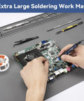 Hands using a soldering iron on a circuit board on Beefy Extra Large Soldering Mat For Electronics Repair 932F Heat Resistant Silicone Workbench Pad.