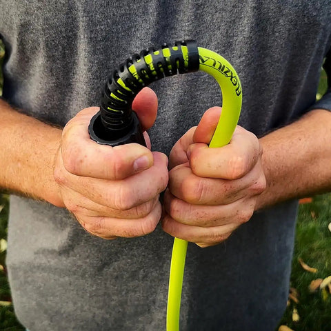 Person holding flexible hybrid Pressure Washer Hose With M22 Fittings 1/4 In By 50 Ft for subzero to 140°F use, ZillaGreen color.