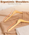 Heavy Duty Wooden Hangers 20 Pack With Non Slip Pant Bar For Closets displayed with clothes on bed