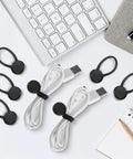 Slick Magnetic Silicone Cable Ties 10 Pack for Laptops with black clips and USB cables on desk.
