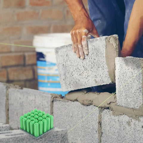 Green Plastic Drywall Anchor Kit With Self Tapping Screws For Gypsum Wallboard shown with bricklaying in background