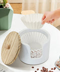 Person placing filter into Go-To Coffee Filter Holder With Lid For Countertop Storage, The Ultimate 8-12 Cup Coffee Station Organizer