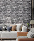 Room with Grey Brick Peel And Stick Wallpaper 17.7 Inch Wide By 236 Inch Long Faux 3D Stone Vinyl Wall Covering behind a modern sofa
