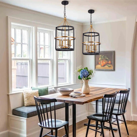 Modern 4 Light Lantern Pendant Chandelier in matte black and brass hanging over dining table in bright kitchen