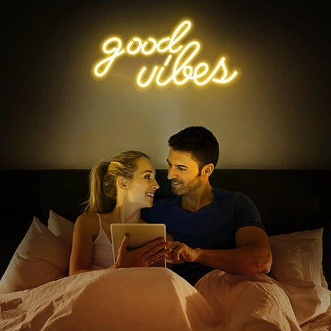 Couple in bed under Good Vibes Neon Sign For Bedroom Decor, Warm White LED Neon Lights For Wall Decor, 16 By 8 Inch Accent Light