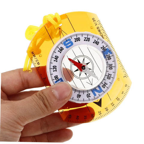 Hand holding orienteering compass pointer lightweight hiking navigation tool for outdoor adventures with luminous coating