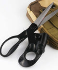 Close-up of black ergonomic sewing scissors with built-in guide beside a tan tactical backpack