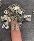 1:12 Scale Miniature Door Hinges With Screws, Set Of 4 For Dollhouse Doors And Cabinets, silver hinges shown on fingertip