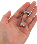 Hand holding a plate with bolts from Four Piece Roller Skate Repair Parts Kit With Five Metal Plates And Mounting Hardware.