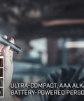 Person holding MicroStream 45 Lumen Everyday Carry Pocket Flashlight With AAA Battery Included in dim workshop.