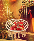 LED Macrame Hammock Chair For Indoor And Outdoor Use, Handmade Cotton Rope Swing With 12m LED String Lights by a cozy fireplace.