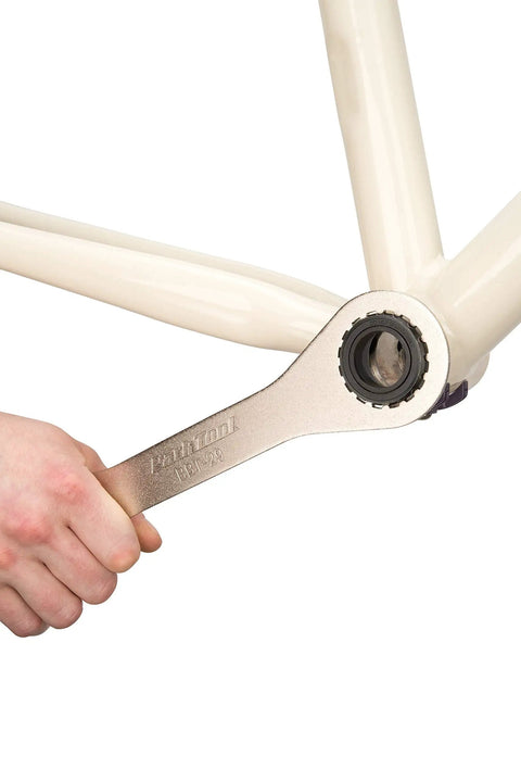 Hand using BBT-29 Double-Ended Bottom Bracket Tool For 16-Notch Cups 39mm And 48.5mm on bicycle frame bracket