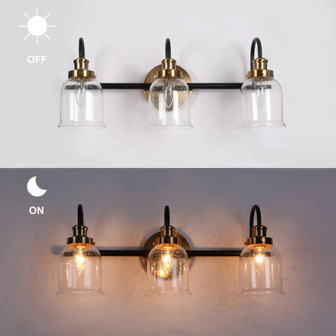 Modern 3 Light Seeded Glass Vanity Light Fixture In Matte Black And Brushed Brass Finish With A Circular Backplate And Three Arched Arms Ideal For Master Bathrooms Or Powder Rooms Spruces Up Your Bathroom With A Dope Mid Century Modern Vibe shown in off and on states.