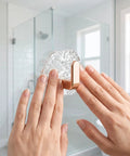 Hands applying Water Ripple Hexagonal Adhesive Wall Hooks to a smooth shower wall, showcasing easy installation and modern design.